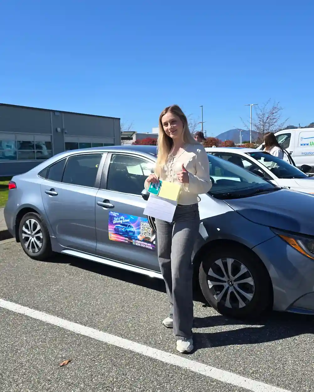 Alisha Danylets after passing her ICBC road test beside the Right of Way training car