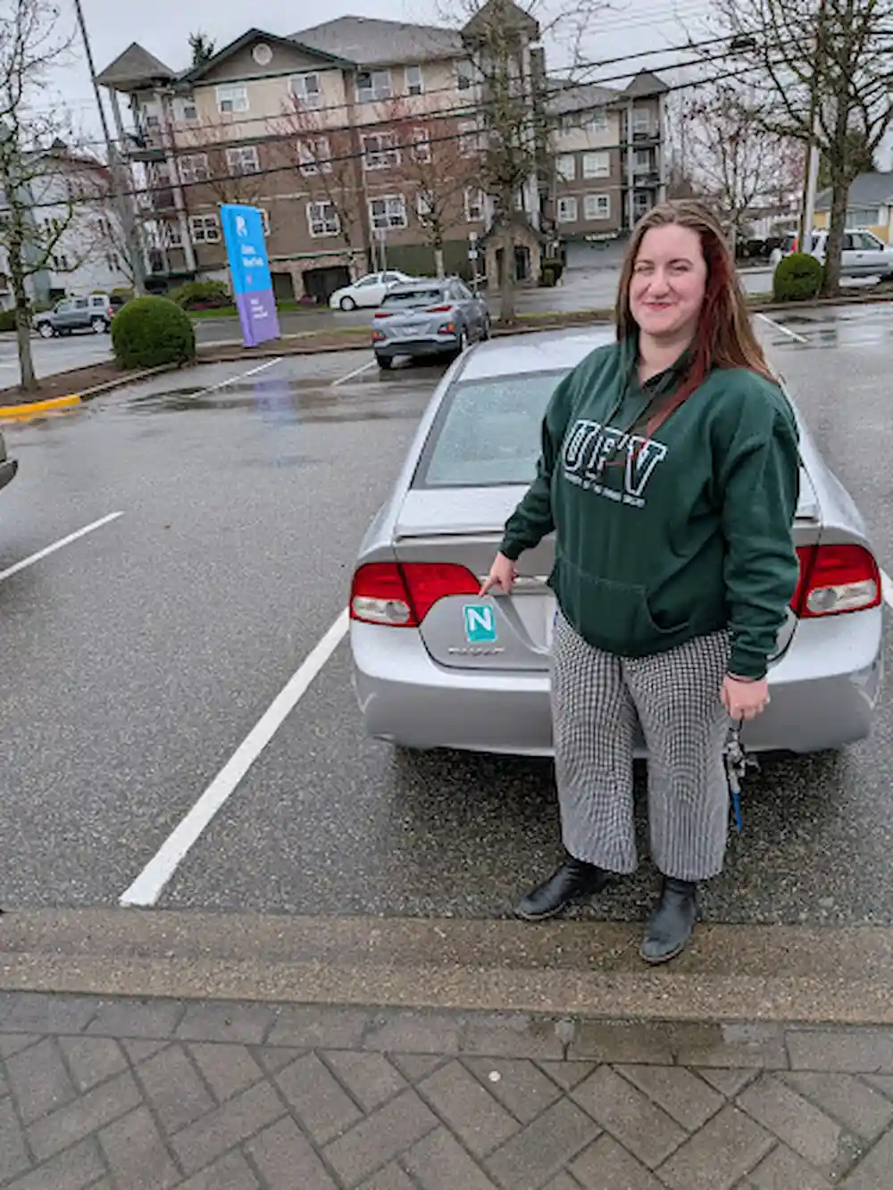 Avery Holwerda holding an N sign after road test training with Right of Way Driving School